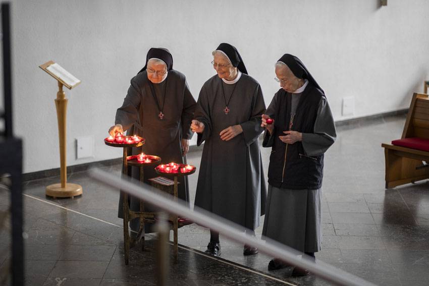 Ordensschwestern zünden Kerze an. Foto: Mika Väisänen / Schervier Altenhilfe